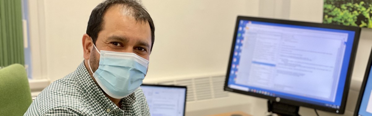 Professor Pratik Choudhary sitting at his desk with a mask on